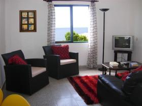Top floor lounge with ocean views next to terrace with covered BBQ and dining area