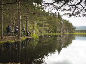 Mountain biking along a loch in the Cairngorms, Scotland