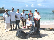 Beach cleaning at Smith Cove, Cayman Islands. Photo by Cayman Islands Tourist Board
