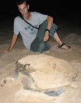 Volunteer with turtle on beach in Ghana